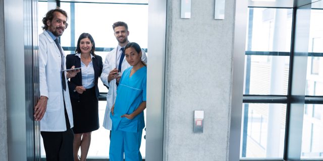 Why the Right Doctor Matters When You or Your Family Is Rare Doctors and businesswoman standing in elevator in hospital