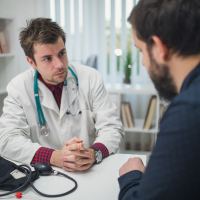 young doctor talking with a male patient
