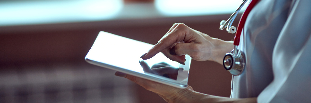 When Doctors Dismiss Health Concerns as 'Hypochondria' doctor using her tablet in the hospital