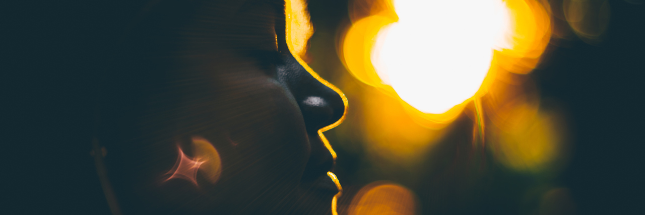 When Fibromyalgia Makes You Too Tired to Talk to People silhouette of a woman standing outside with her eyes closed at sunset