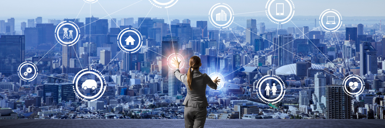 Thinking About Life With Chronic Illness in Terms of Resources woman looking at abstract network of icons with a city in the background