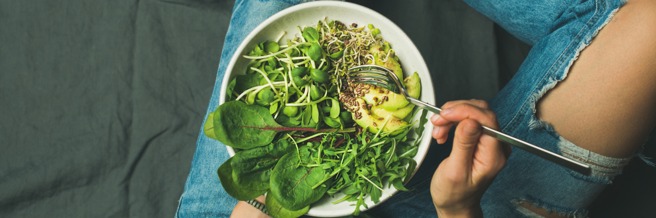 7 Ways My Chronic Illnesses Changed My Relationship With Food A woman holding a bowl of green vegetables.