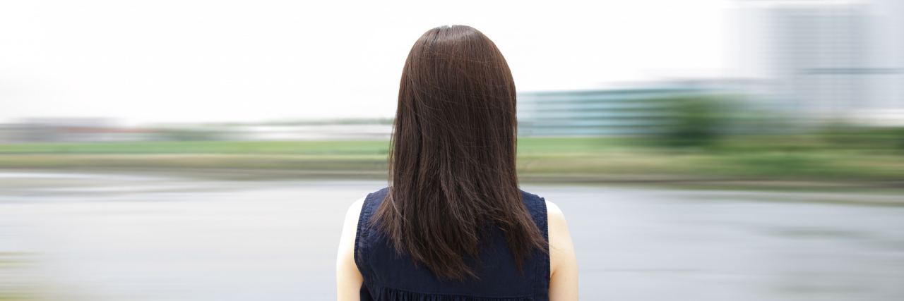 A woman looking at a blurred background.