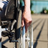 Aged strong lady rolling the wheelchair
