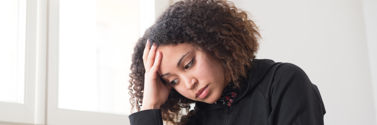 Feeling Abnormal Symptoms When Living With Pompe Disease Alone and lonely young girl feeling depressed sitting with her hand on her head