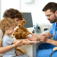 doctor talking to a mother and her son