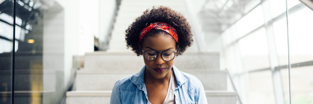 5 Simple Things My Employers Do That Help Me Work With Disability Focused young woman working on a laptop on some stairs on campus preparing for an exam