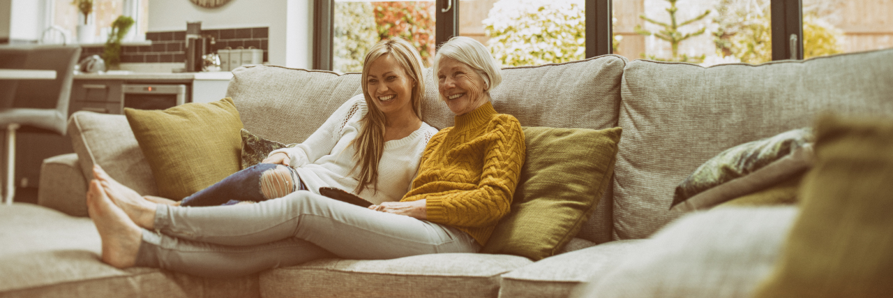 Autism and Being 'Functional' Mother and daughter watching television together on the sofa at home.