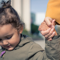 Close up of little girl holding hands with her mother. Mother and daughter bonds.