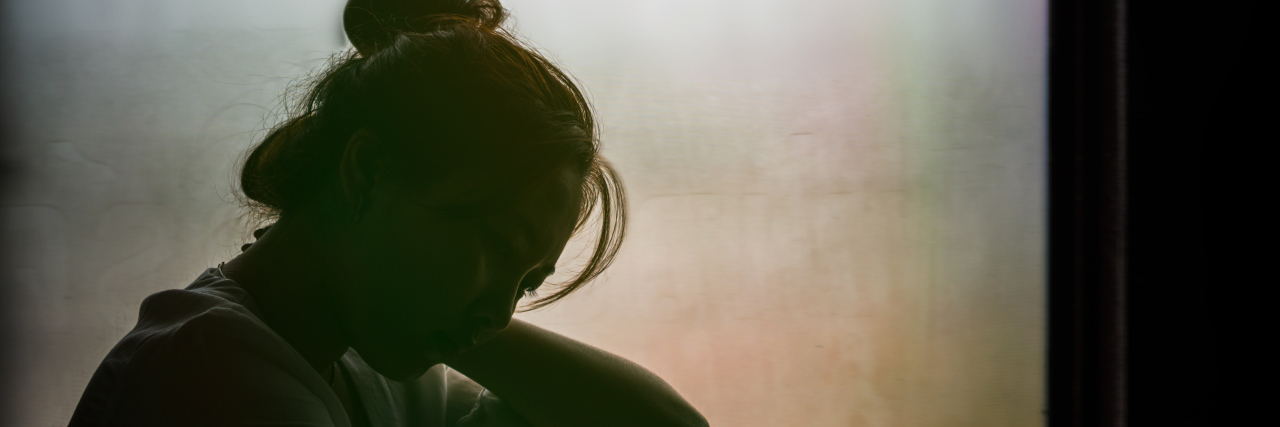 What Grief Steals From Me Every Day Vintage filtered on silhouette of depressed girl sitting on the window