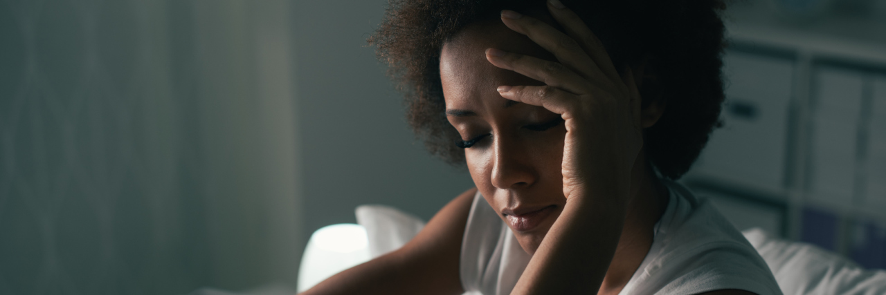 woman holding head looking sad