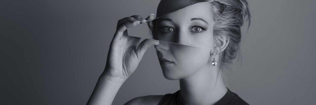 The Two Types of Narcissistic Personality Disorder double exposure black and white photo of woman holding shard of mirror up to face covering eyes with different reflection
