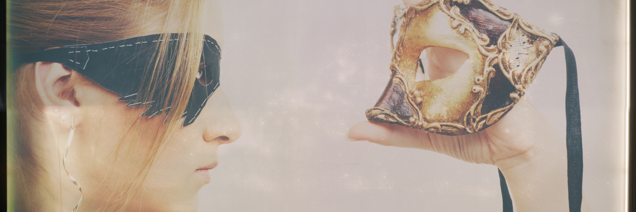 Passing as 'Normal' With Mild Cerebral Palsy Woman holding masquerade mask and wearing a black mask.