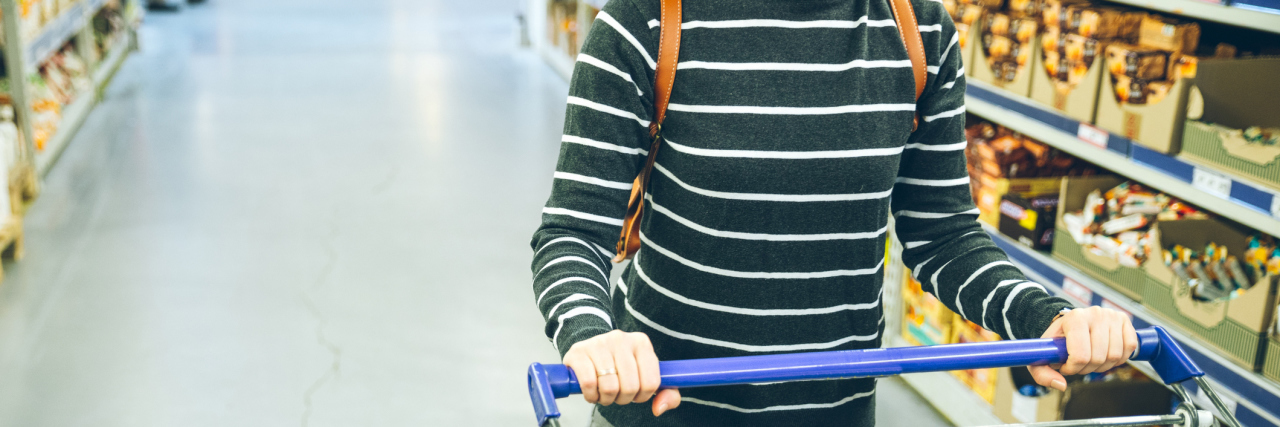 How One Stranger Went Out of Her Way When My Health Was Struggling A woman in the grocery store pushing a cart.