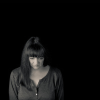 Minimal portrait of woman with problems looking down.