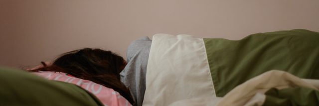 Young woman is sleeping from the back in bed