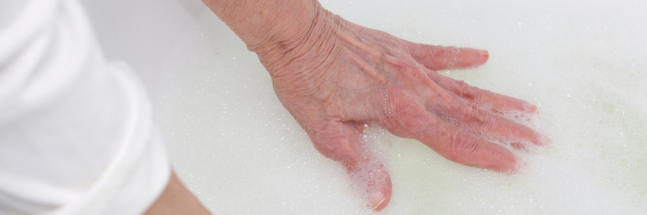 Senior woman between 70 and 80 years old wants to take a bath.