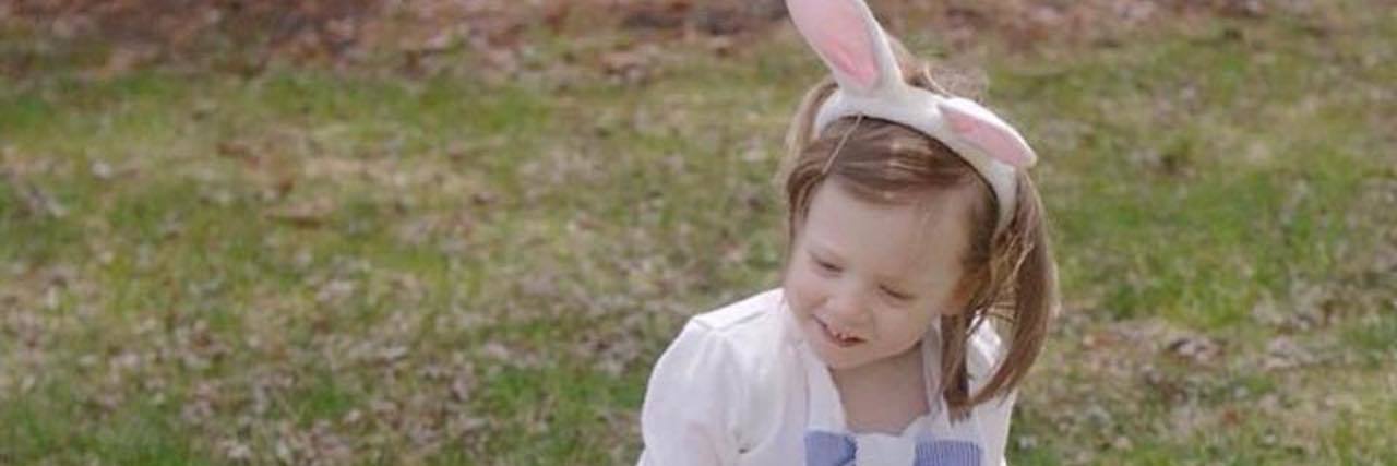 Easter Egg-Hunt Adaptations for Kids With Disabilities Little girls using walker, wearing bunny ears and two pink baskets and on the sides of the wakler