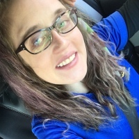 woman wearing a blue shirt and glasses and taking a selfie on her last day of work