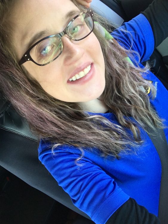 woman wearing a blue shirt and glasses and taking a selfie on her last day of work