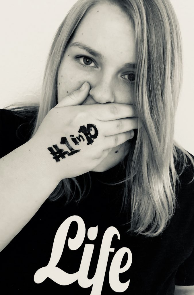 woman covering her mouth with her hand, and on her hand is written 'one in ten'