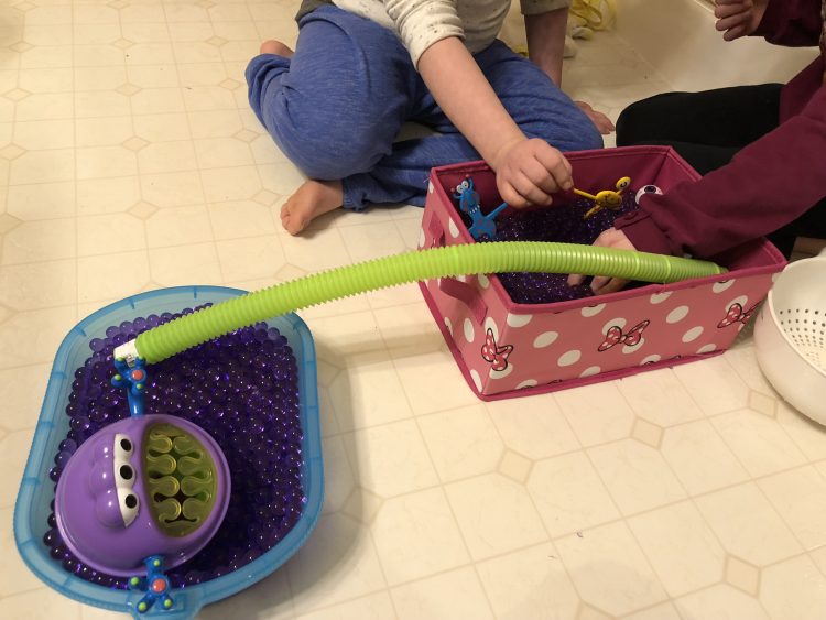 Girls playing with sensory boxes with water beads