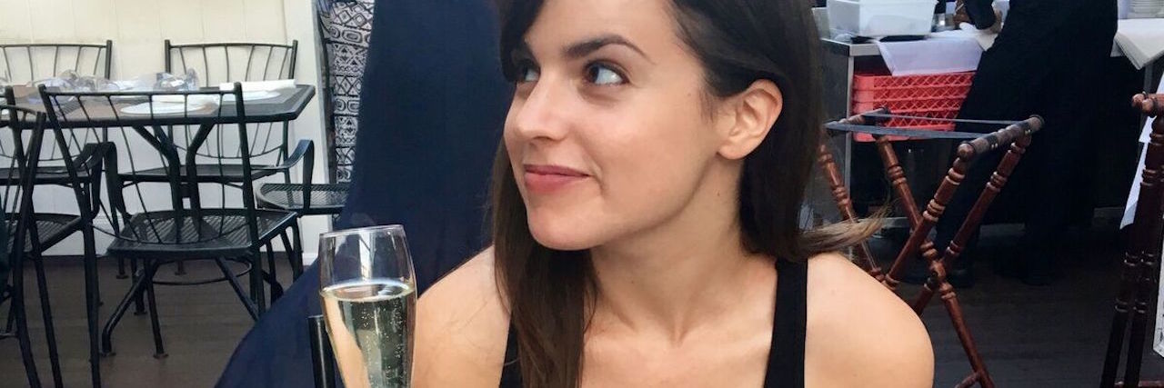 Falling in Love With Food Again After Having My Colon Removed woman eating pasta and drinking prosecco at a restaurant