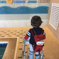 little boy with walker near a pool