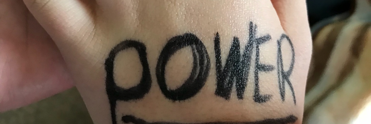 When My Son With Down Syndrome Noticed His Uniqueness Hand with little pinky bent a little. On the hand with black marker the word: power