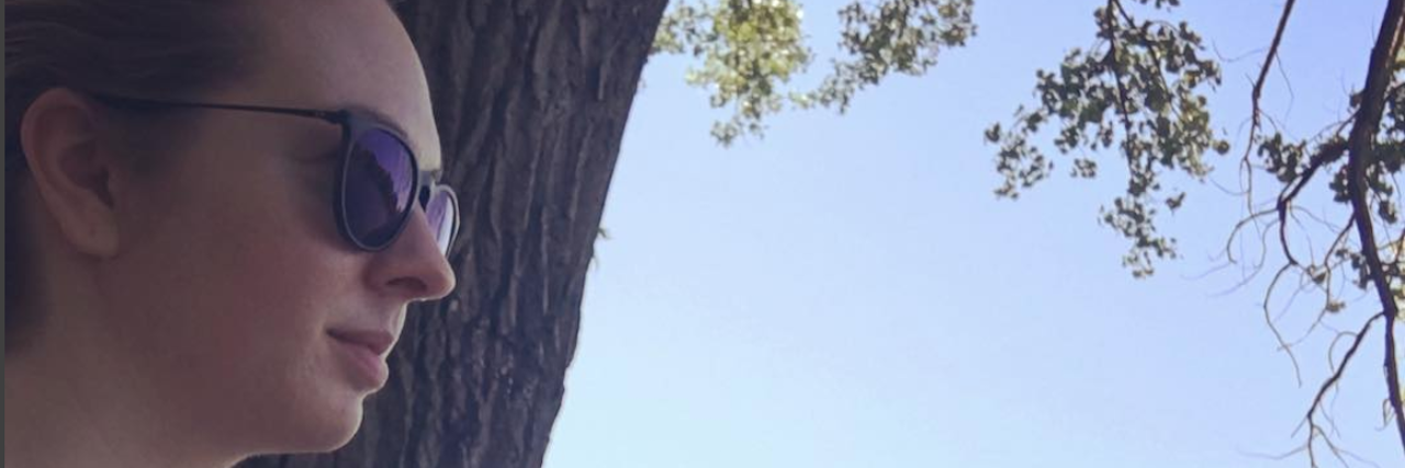 How the #MeToo Movement Taught Me to Share My Lyme Disease Story A photo of the writer outside standing by a tree.