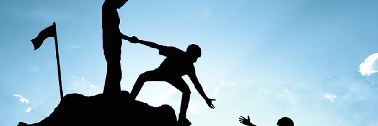 How to Support People With Chronic Fatigue Syndrome silhouette of climbers helping each other up a mountain against a blue sky