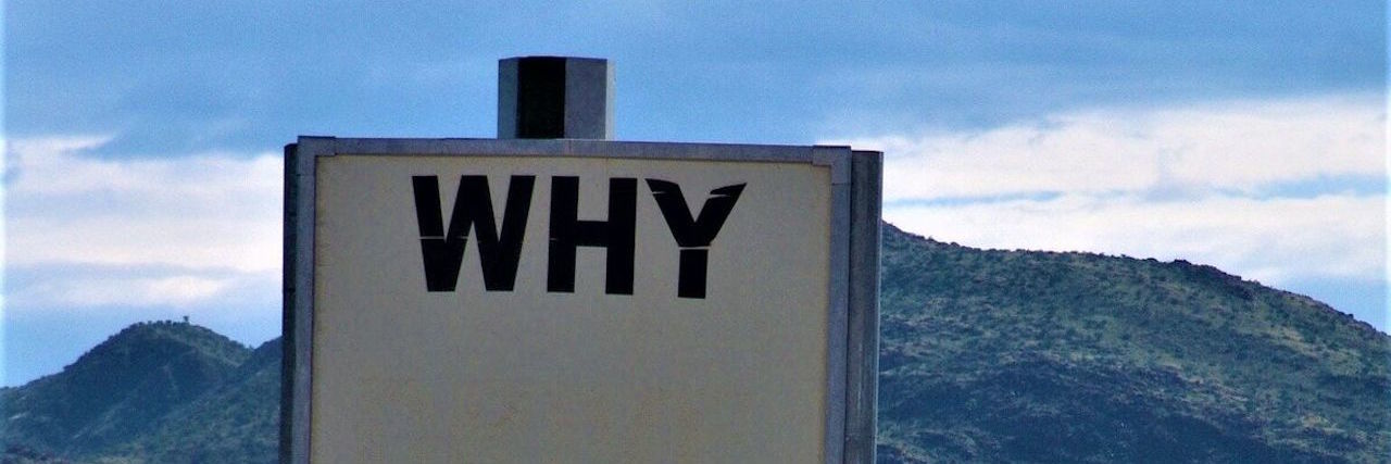 The Contradictory Ways People Respond to My Chronic Pain a large white sign that says "why?" in the middle of a field with a mountain in the background
