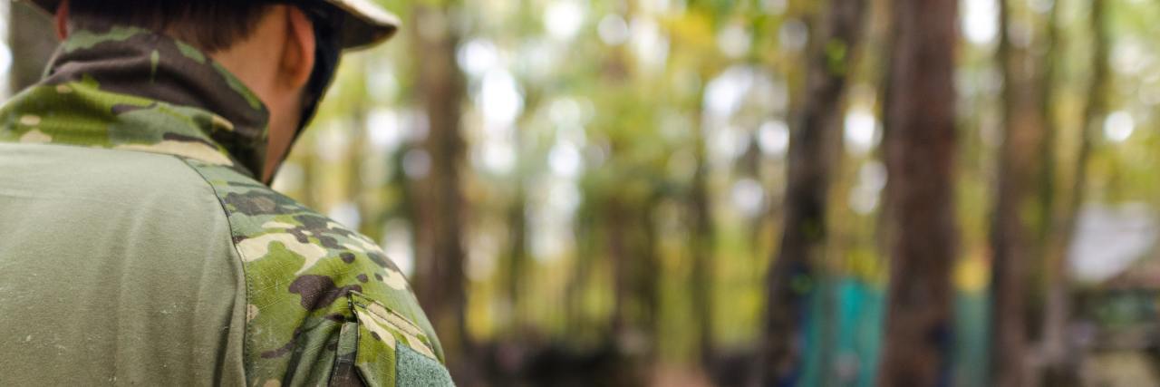 How Military Demands Led to My Bipolar Disorder Diagnosis male soldier army in forest park with bench nearby