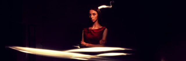 woman in dark room with lights swirling around her