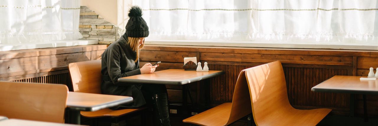 Seeing Someone With an Eating Disorder in a Restaurant A woman sitting at a table alone in a restaurant