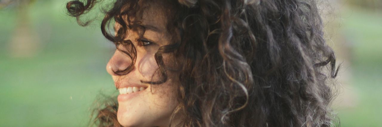 woman with curly hair smiling