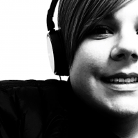 Black and white image of close up face boy wearing headphones smiling at camera