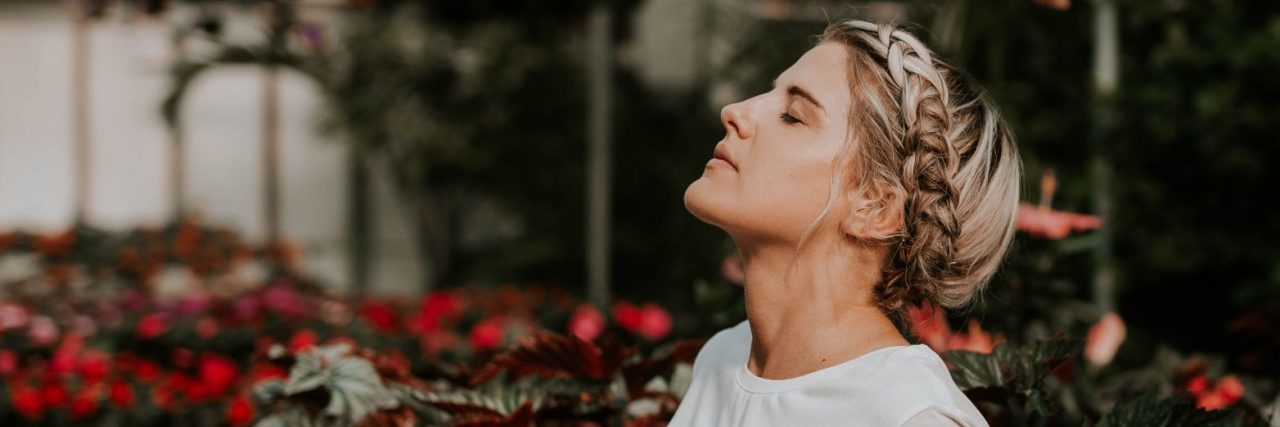 Why I See Bipolar Disorder as a Gift, Not a Weakness young woman looking content surrounded by flowers