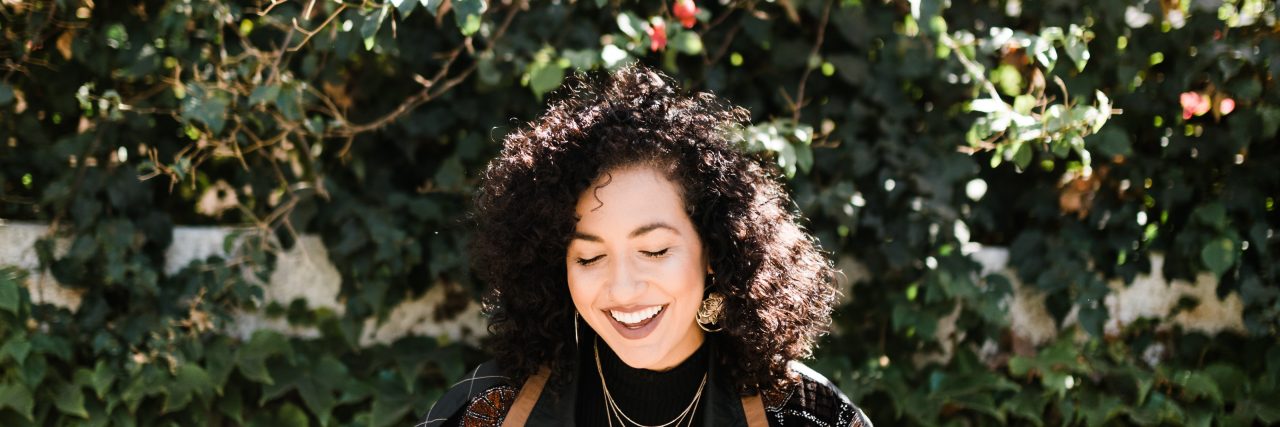 5 Tips on How to Use Humor to Manage a Trip to the Doctor woman laughing in front of flowers