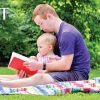Picture of a man with Down syndrome reading a book to a little kid while sitting on a blanket