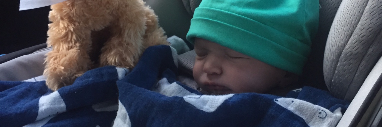 Theo, the author's son sleeping in a carseat with a stuffed animal