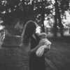black and white photo of woman holding her baby outside