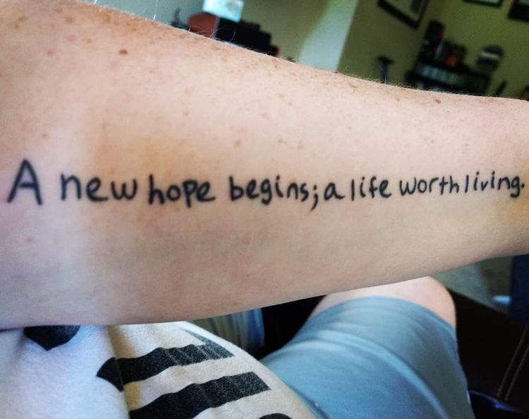 Tattoo across the inside of an arm with the words "A new hope begins; a life worth living."