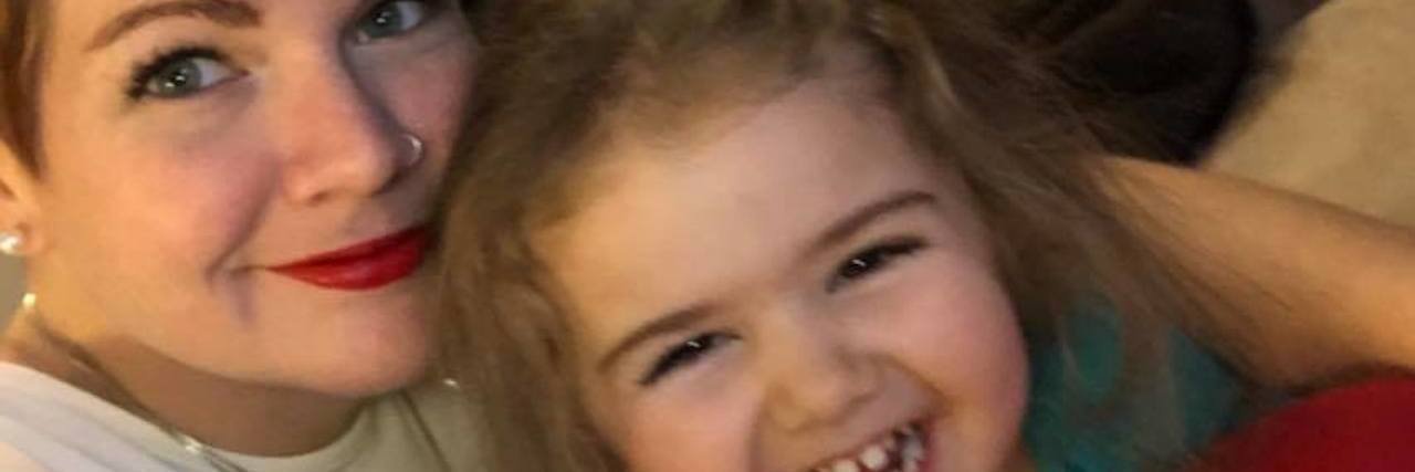 A Glimpse of Parenting With a Chronic Illness Mother and daughter smiling at camera, mother is laying down