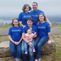 Family of 6, baby has Down syndrome, they all wear a blue shirt that says "provethemwrong