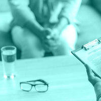 Cropped image of depressed man at the psychotherapist. Doctor is making notes while listening to his patient