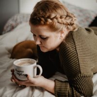 woman drinking coffee in bed