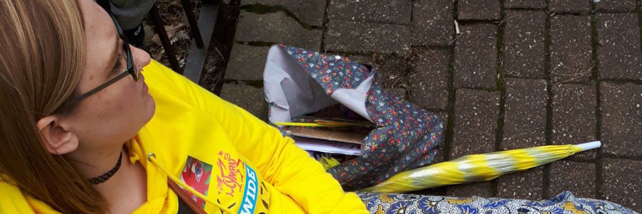 Sharing a Photo of Me in Pain During the Endometriosis March woman sitting on the ground in a yellow sweatshirt