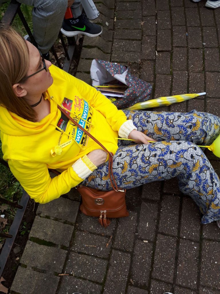woman sitting on the ground in a yellow sweatshirt