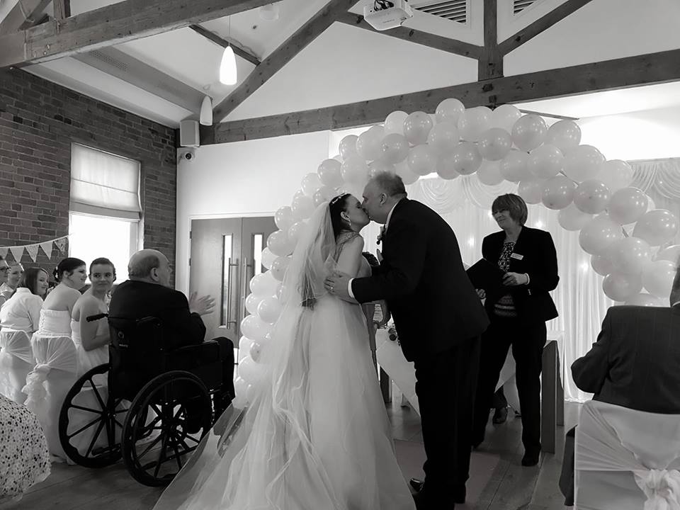 black and white photo of husband and wife kissing at their wedding